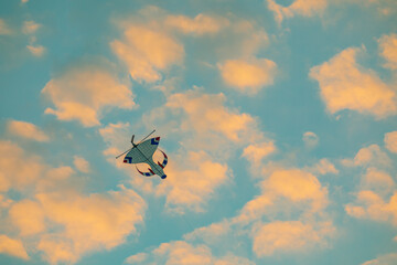Sunset colourful kite in the sky with fluffy clouds and orange