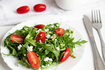 Green vegan salad with arugula leaves and cherry tomatoes. Snack, food