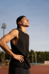 Young male athlete concentrating before training by inhaling and exhaling air. Sport concept body...