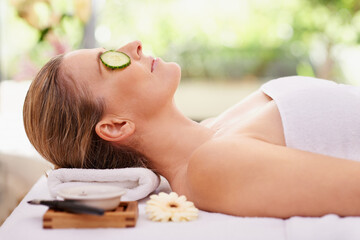 Obraz na płótnie Canvas Woman, relax and cucumber with towel at spa for facial treatment, care or peace at hotel or outdoor resort. Calm young female person in relaxation, zen or stress relief for natural beauty or skincare