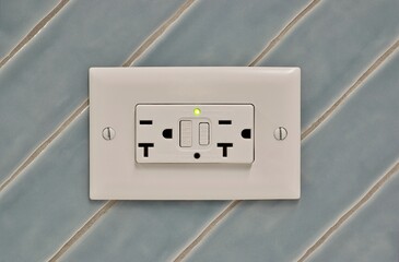 Twin power outlet duplex socket on a tiled wall, USA NEMA 5-15 connection. Power electricity and safety conceptual image with copy space.