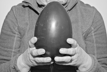mani che reggono uovo di pasqua al cioccolato foto in bianco e nero	 - obrazy, fototapety, plakaty