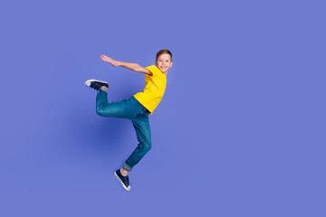 Fototapeta na wymiar Full length photo of good mood nice boy wear stylish yellow clothes open hands fly air isolated on violet color background
