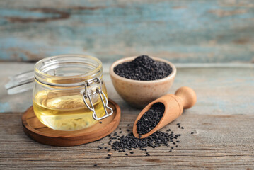Black sesame seeds in bowl and oil in glass jar - 764037196