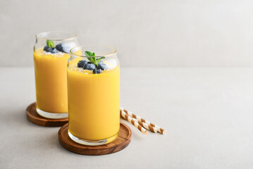 Refreshing and healthy mango smoothie with coconut flakes and fresh blueberries - 764037318
