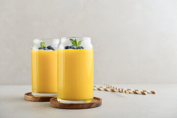Refreshing and healthy mango smoothie with coconut flakes and fresh blueberries - 764037324