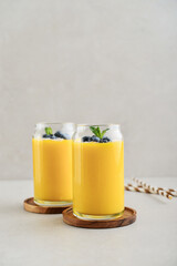 Refreshing and healthy mango smoothie with coconut flakes and fresh blueberries - 764037325
