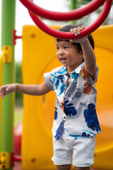 Fototapeta na wymiar Adorable preschool boy enjoying bar lifting in outdoor playground in city park