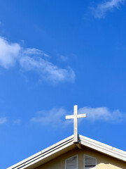 Cross over the church with blue sky.