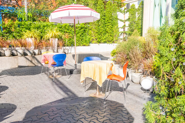 Outdoor empty coffee and restaurant terrace with tables and chair ,umbrella in open cafe, luxury tropical cafe,Summer vacation destination concept.