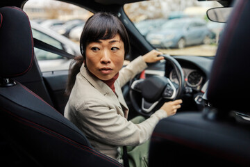 A japanese middle aged woman is parking her car.