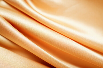 yellow silk satin, draped fabric, gold color, elegant background. Beautiful wavy area for design, Close-up of blurred or blurred.