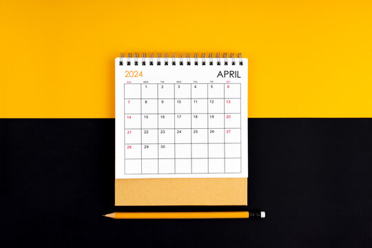 Top view of April 2024 desk calendar and pencil on yellow and black