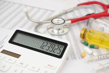 Calculator and stethoscope with drugs and vaccines on documents.