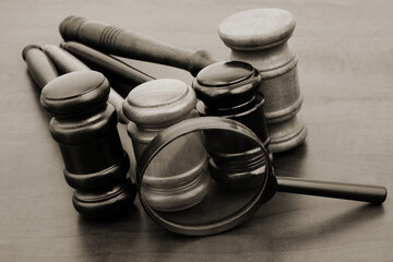 Court decisions review concept. Judge gavels under magnifying glass on table.