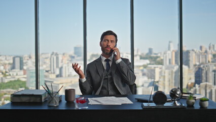 Relaxed boss speaking telephone in office chair closeup. Handsome man consulting