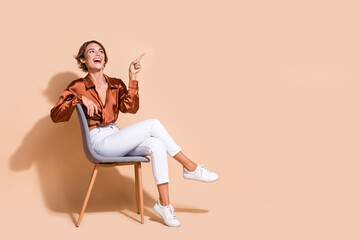 Full length photo of cheerful dreamy lady dressed brown top sitting chair showing looking empty...