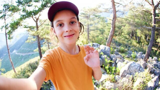 Cute boy takes a selfie using a mobile phone. trip to the mountains. hiking and active healthy lifestyle. adventure holidays with children.