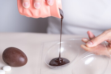 Sequence of a woman molding chocolate Easter eggs in her kitchen. melted chocolate, spice event, home, lifestyle concept