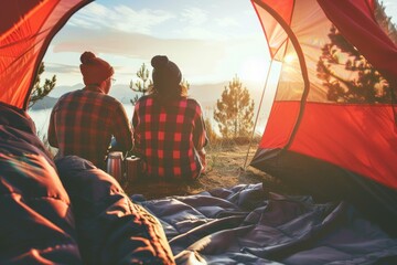 A couple in warm clothing sits by a tent admiring the sunrise, symbolizing adventure and companionship in nature - obrazy, fototapety, plakaty