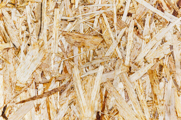 Particleboard close-up texture, abstract background. OSB sheet made from compressed brown wood chips