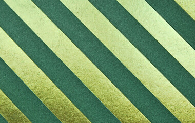 Dark green and golden diagonal stripes cardboard texture as background 