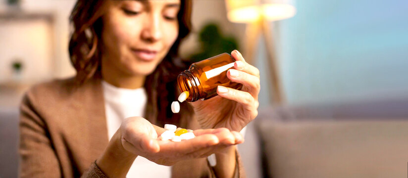 Mensch wirft Tabletten aus einem Medikamentenglas in die Hand 