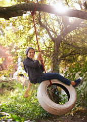 Boy, child and tyre swing with portrait in garden with smile, playing and countryside vacation in...
