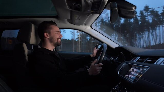Man enjoying in driving a car on city street in evening