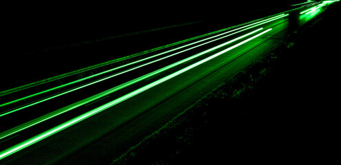 Fototapeta na wymiar green car lights at night. long exposure