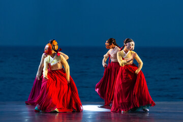 a traditional Korean dance performance in which female dancers wearing a jeogori and a red skirt perform