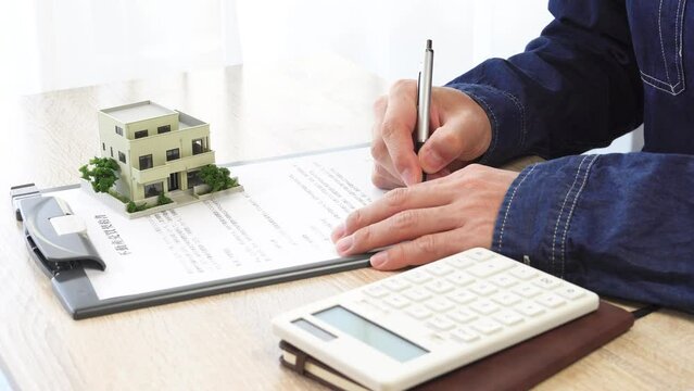 契約書にサインする男性の手