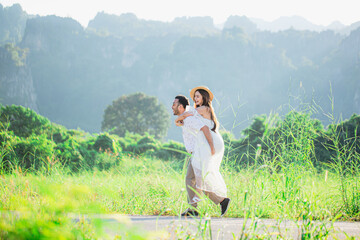 Man carries his girlfriend on his back,Young couple surrounded by mountains and nature,Young couple proposes marriage,Surrounding stunning scenery with views of mountains and valleys