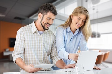 Naklejka na ściany i meble Happy business team work together on laptop