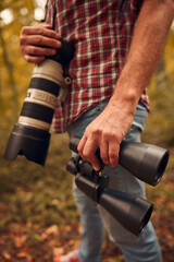 Naklejka premium Man using binoculars and camera for birdwatching and other observing animals in nature.