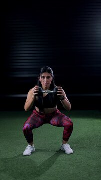 Woman with athletic body doing exercises with a dumbbell. Sports advertising concept