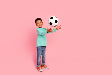 Full length photo of adorable little boy catch soccer ball dressed stylish cyan garment isolated on pink color background - obrazy, fototapety, plakaty