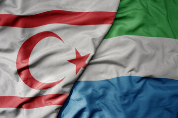 big waving national colorful flag of sierra leone and national flag of northern cyprus.