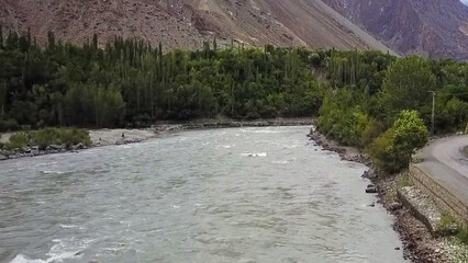 path in the mountains Flowing river, tall green trees, mountain top, dark white clouds, cold weather, green road