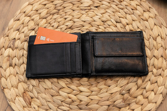 Portfel z kartą kredytową w kolorze pomarańczowym, koncepcja płacenia rachunków wyłącznie kartą lub korzystania z karty kredytowej.






