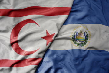 big waving national colorful flag of el salvador and national flag of northern cyprus.