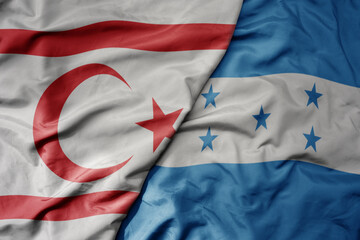 big waving national colorful flag of honduras and national flag of northern cyprus.