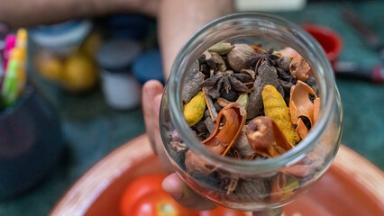 A hand holding Morrocan spices in a glass jar