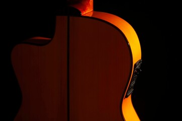 Classical Spanish flamenco guitar close up, dramatically lit isolated on black background with copy...