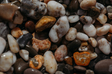 Sea stones of different colors on the shore in close-up