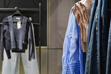 Women's clothes on hangers in a retail shop. Fashion and shopping concept