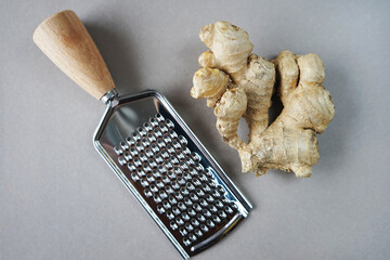 Ginger root with grater on light background