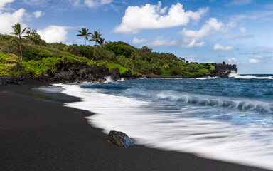 Black sand beach in Maui with ocean