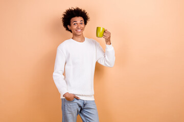 Photo of cheerful man wear white trendy clothes hold mug tasty caffeine refreshing drink isolated on beige color background