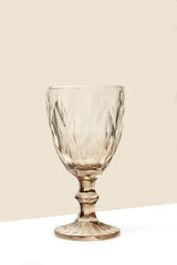 Copa de cristal sobre un fondo beige y blanco. Vista de frente y de cerca. Copy space. Formato vertical - 764132181